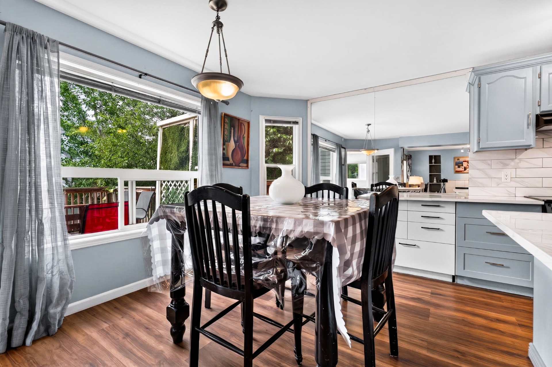 Sunlit dining nook with large window overlooking the back deck