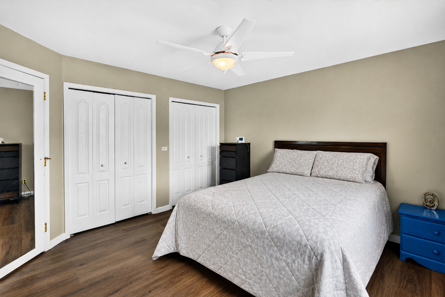 Bedroom showing bed placement, storage closets, and open floor area