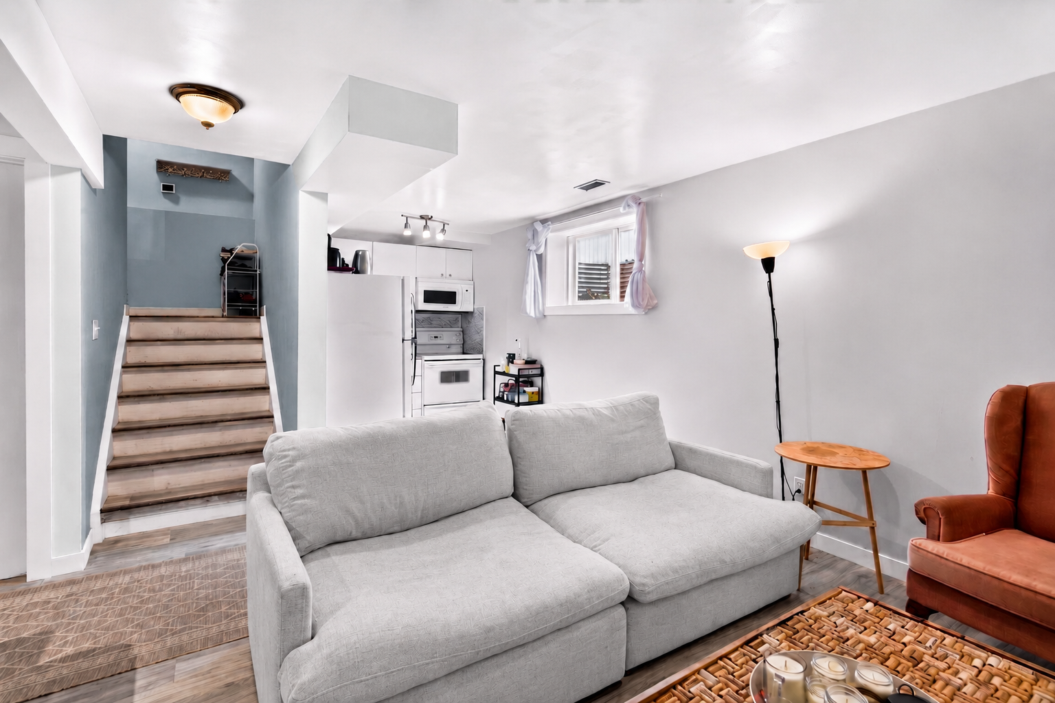 Lower-level living space with seating area and kitchenette access