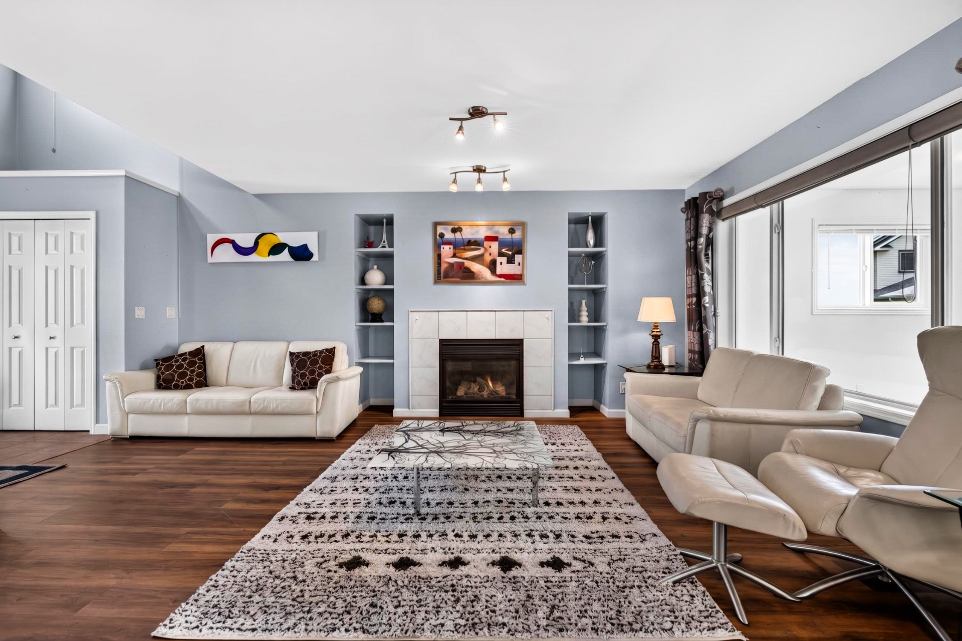 Living room view of fireplace flanked by symmetrical built-in display niches