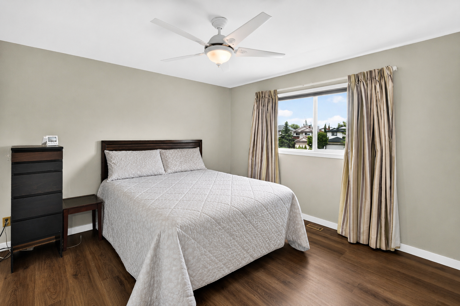 Bright bedroom with large window and clean layout