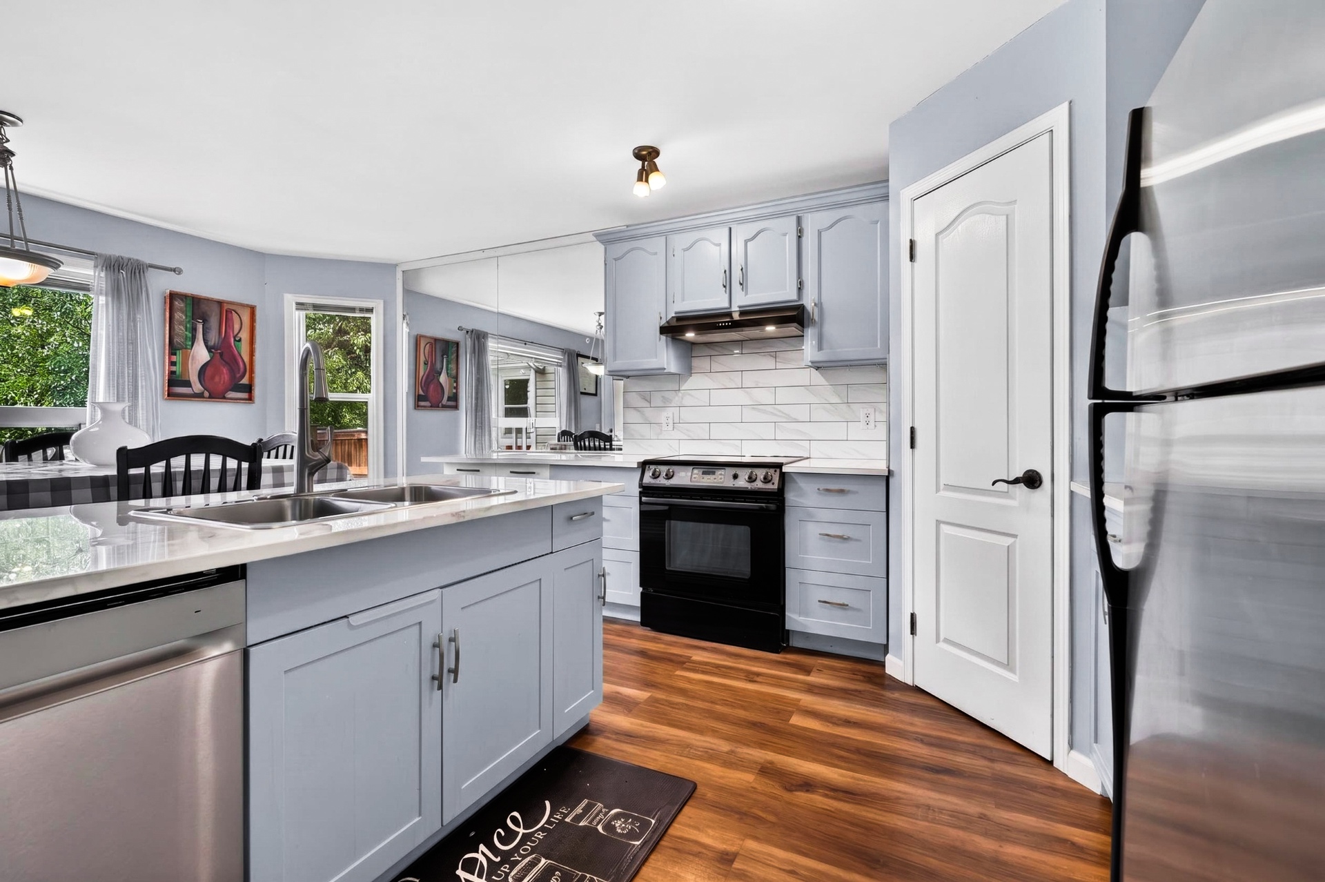 Refreshed kitchen with light cabinetry, quartz counters, subway tile backsplash, and stainless appliances